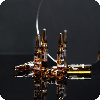 Amber glass ampoules arranged on a dark reflective surface