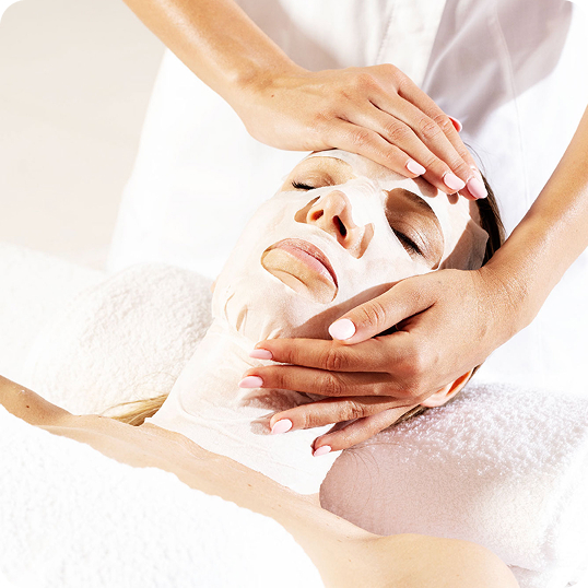 Hands performing a facial massage treatment on a woman's face