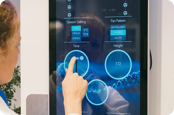 Hand touching a device touchscreen showing treatment settings