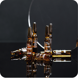 Amber glass ampoules on a dark reflective surface