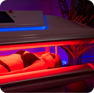 Person lying in a red LED light-therapy bed