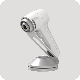 White handheld treatment device with rounded head on a chrome stand
