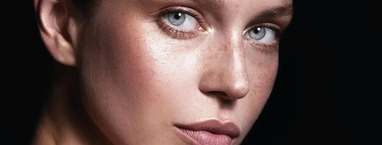 Close-up of a woman's face showing freckles and skin texture